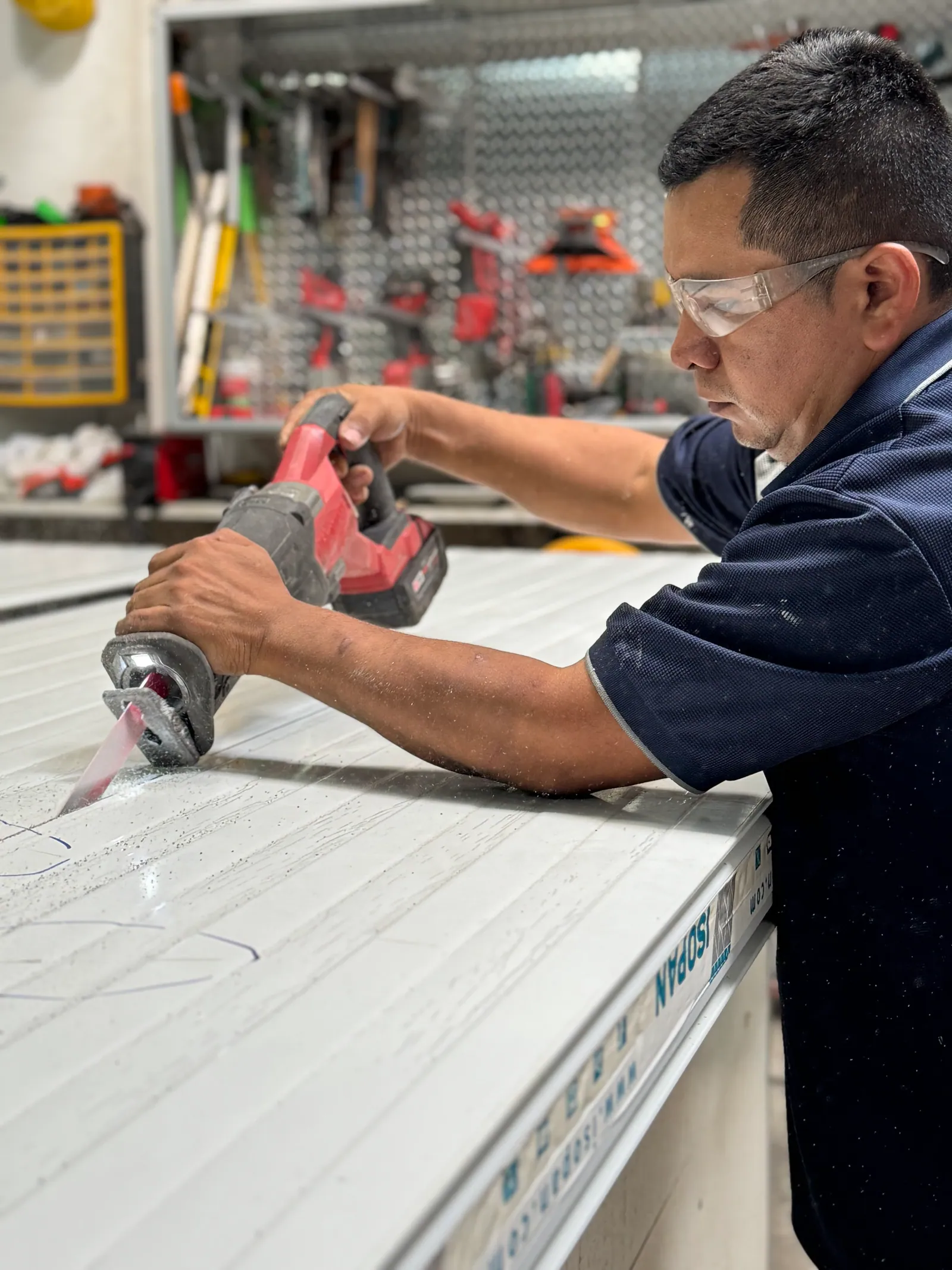 Técnico de INPRE cortando un panel para cuarto frío en el taller